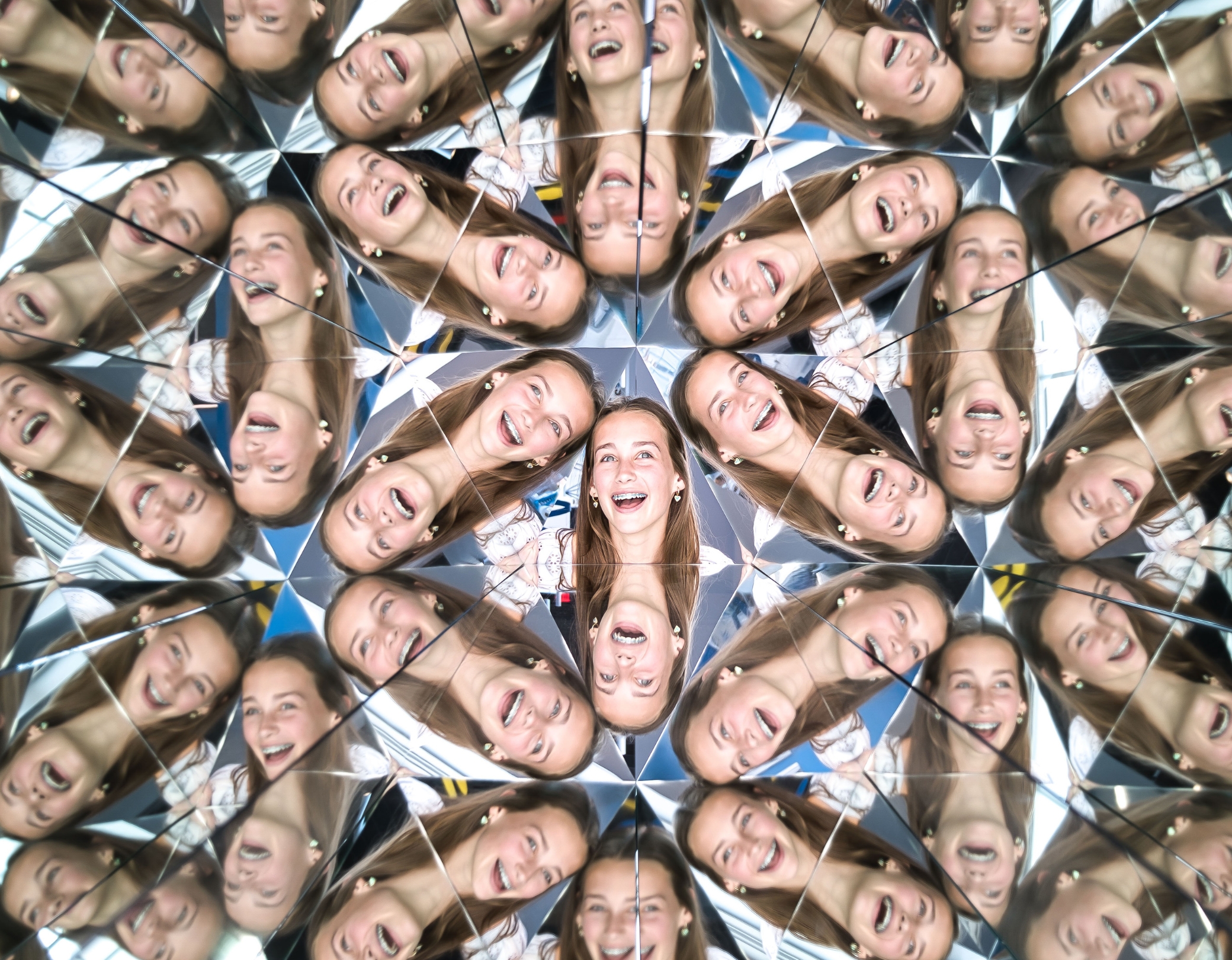 Smiling girl reflected multiple times in a kaleidoscope at the Museum of Illusions Hamburg