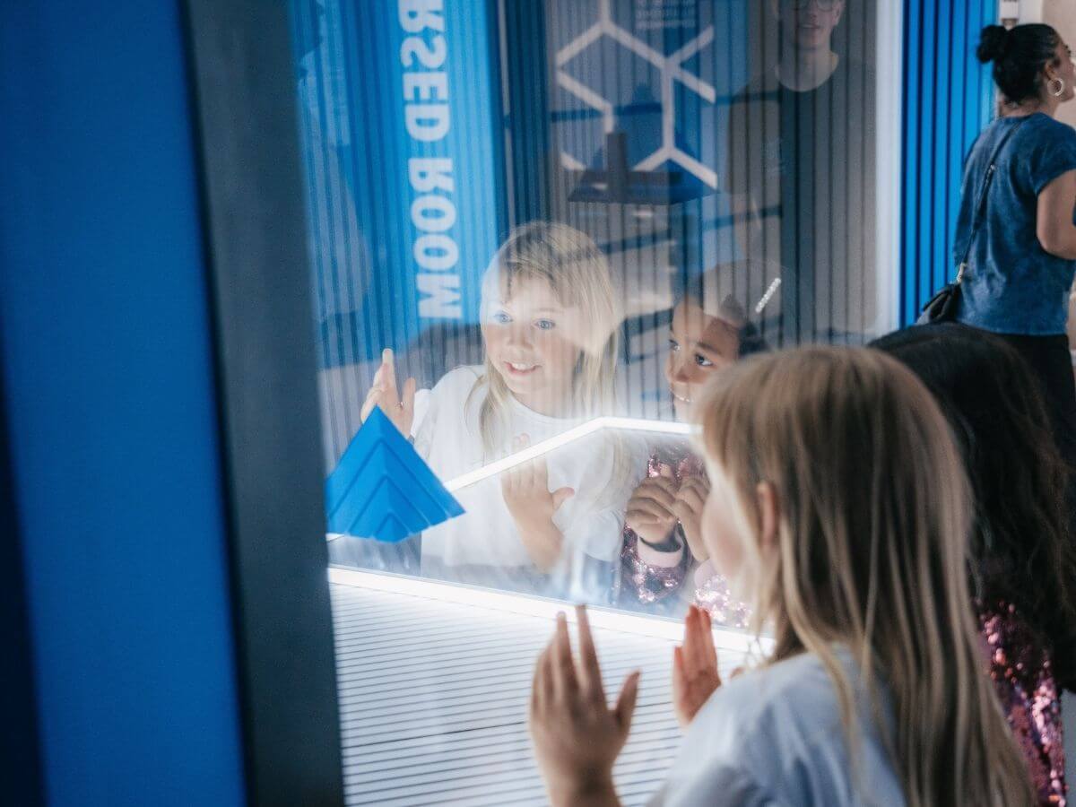 Ein Kind blickt erstaunt auf eine optische Illusion im Museum der Illusionen Hamburg