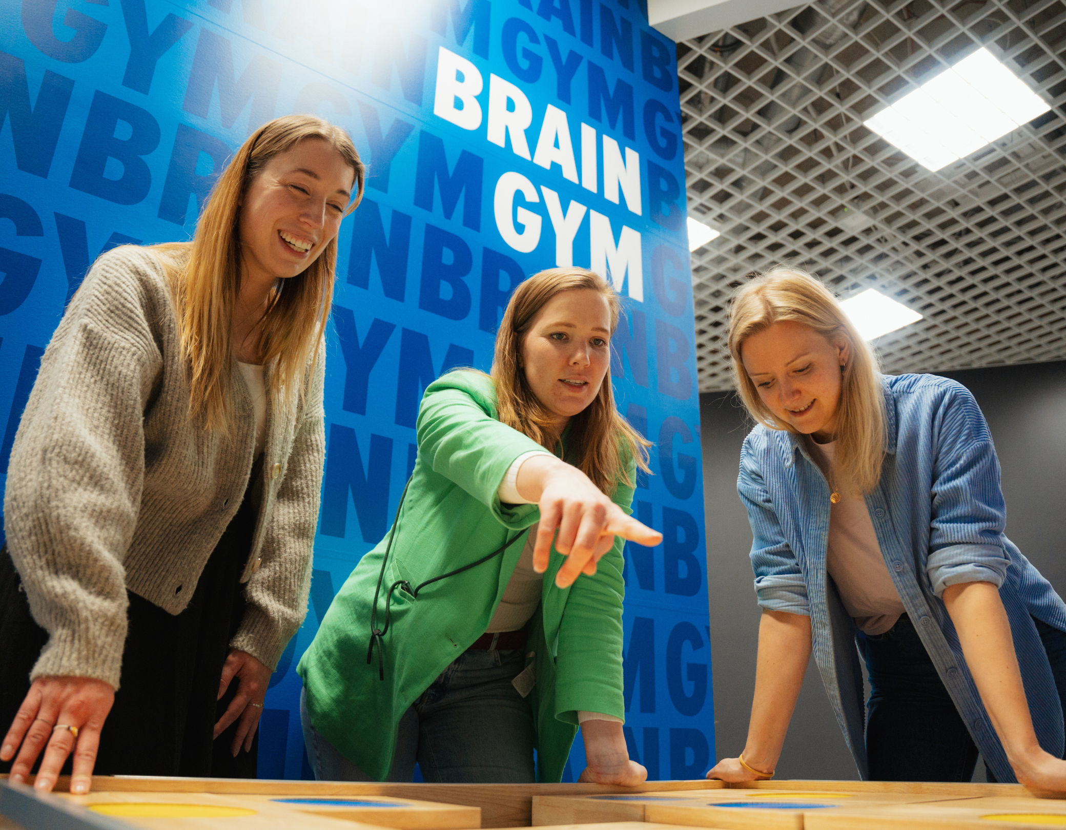 Drei Frauen stehen in der Brain Gym im Museum der Illusionen und versuchen ein Dilemma Game zu lösen