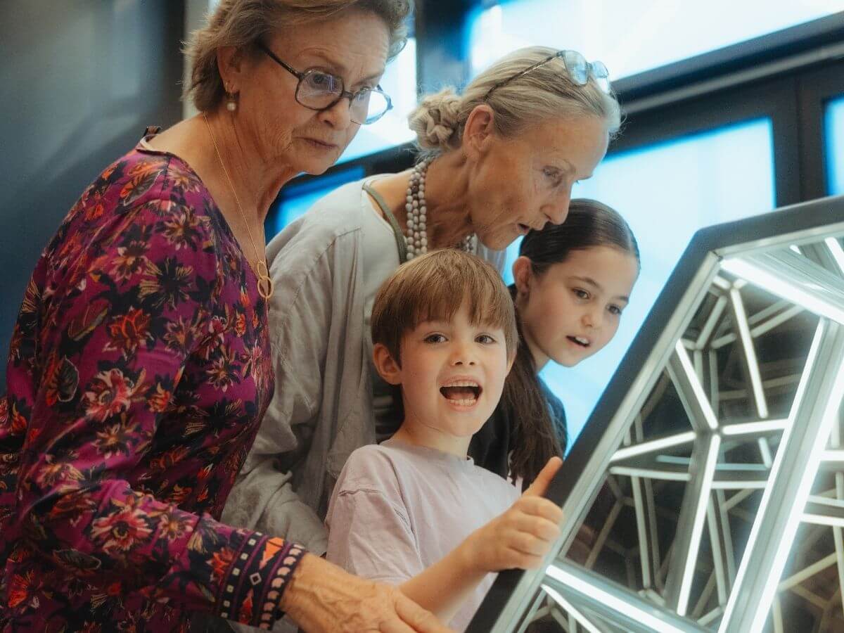 Zwei Großmütter betrachten neugierig ein Exponat im Museum der Illusionen.